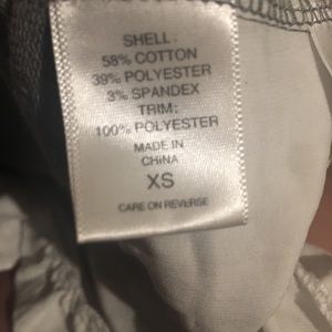 Short grey dress with white ruffles and pockets.